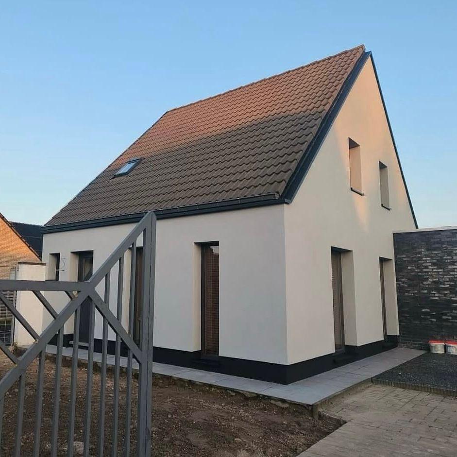Woning met crème gekleurde crepi gevel en donkere dakrand na gevelwerken door Enervea