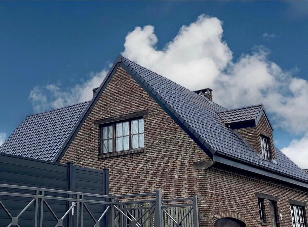 Bakstenen woning met vernieuwd dak in donkere keramische pannen