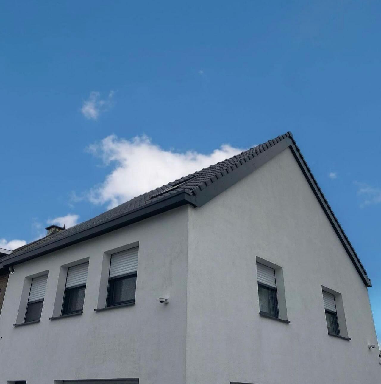 Woning met strakke lichtgrijze crepi-gevelafwerking na gevelisolatie