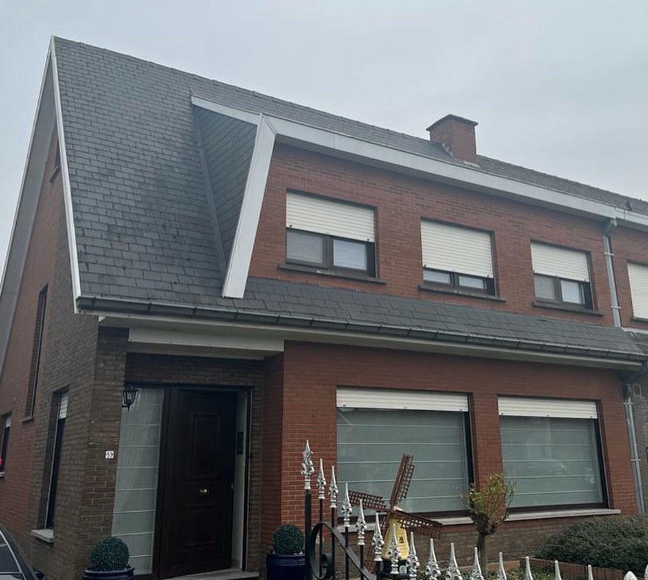 Woning voor de dakrenovatie met verouderde dakpannen en versleten dakbedekking
