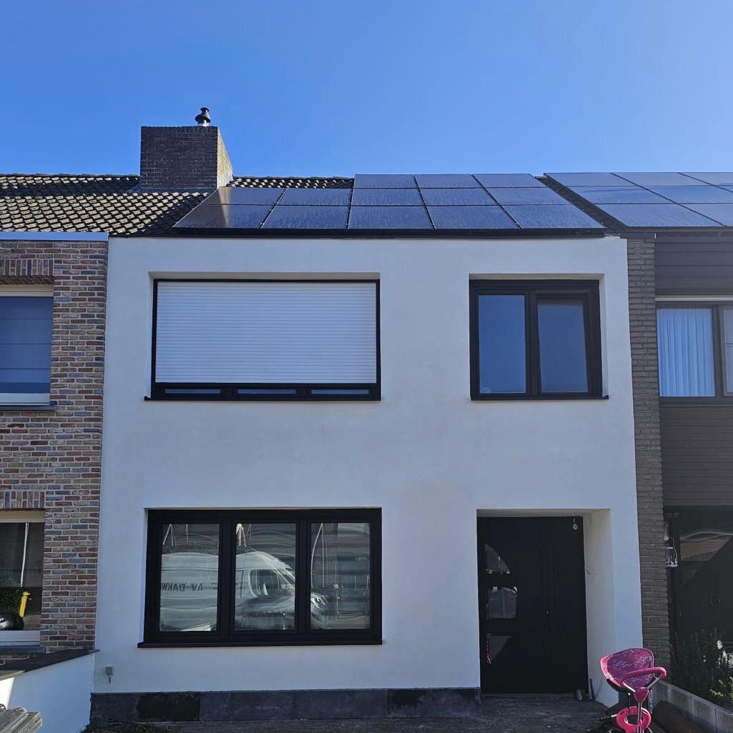 Gerenoveerde rijwoning met witte crepi gevel en zonnepanelen op het dak
